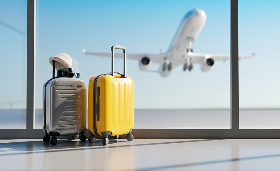 A yellow and silver hard shell luggage in the airport